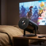 Kompakter Mini-Beamer bei der Filmwiedergabe in einem abgedunkelten Schlafzimmer.